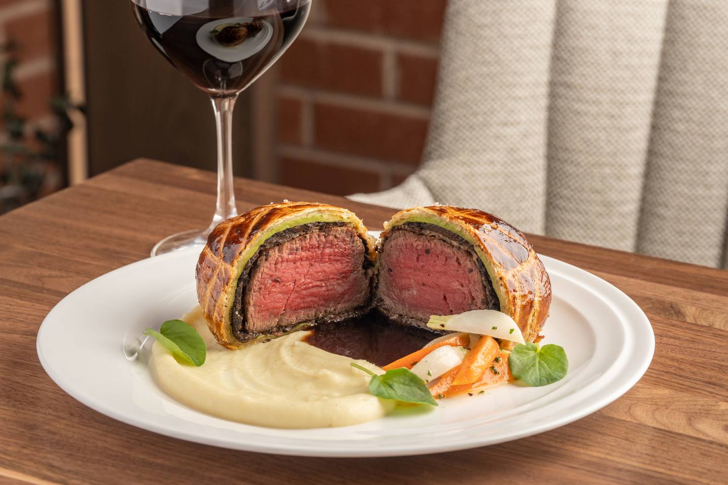Beef Wellington is a rich and tender starter with silky bone marrow with sweet caramelized onion jam and whipped butter, presented on a toasted baguette. This is available at Ramsay's Kitchen in downtown Naperville.