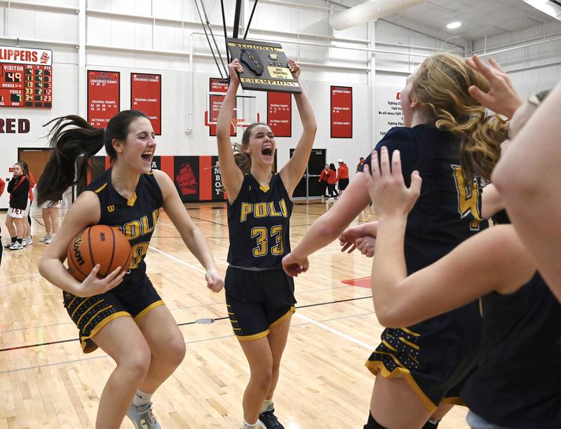 Polo's Annalise Stamm (left) holds the game ball while Lindee Poper (33) holds up the regional championship plaque for her cheering teammates Friday night in Amboy. The Marcos won their first regional title since 2008.