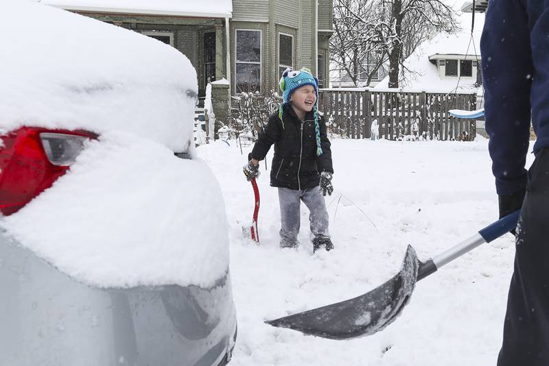 Elijah Halm helps his father Richard dig his car out on Sunday, Jan. 31, 2021, in front of their house in Joliet, Ill.  Nearly a foot of snow covered Will County overnight, resulting in fun for some and challenges for others.