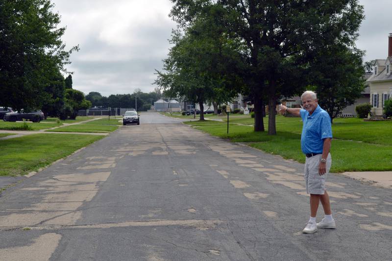 Mt. Morris Village Board Trustee Ed Higley, who is in charge of the streets, stands in the middle of Sunset Lane on Friday, Aug. 2, 2024, and points to the two blocks that have been redone. The Sunset Lane Project involves reconstructing the entire 5.5-block street, but is on pause this year while village officials review project financing options.