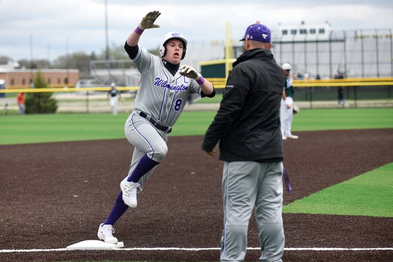 Wilmington's Kyle Farrell, left, high-fives head coach Mike Bushnell as he rounds third base to score on a home run during a game at Coal City Monday, April 21, 2025.