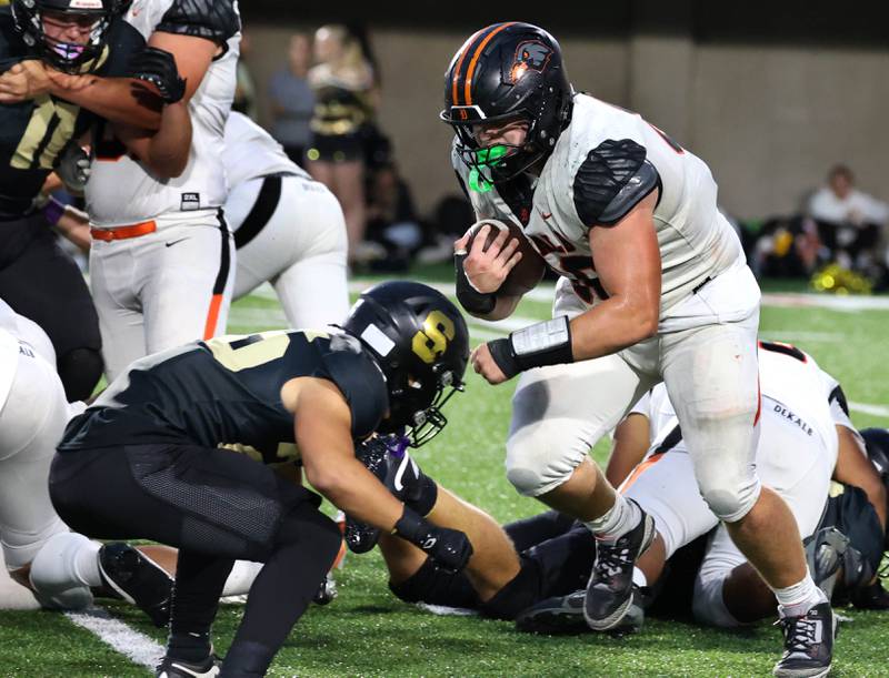 DeKalb's Owen Sisson carries the ball for a first down before being tackled by Sycamore's Caden Ralph Friday, Aug. 29, 2025, during the FNBO Challenge in Huskie Stadium at Northern Illinois University.