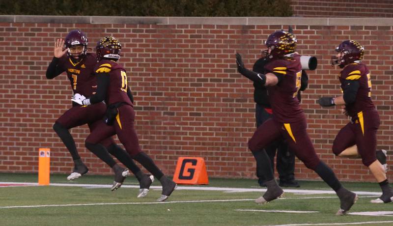 Montini Catholic's Israel Abrams, hi-fives teammate CJ Harkins after scoring a touchdown against Monticello during the Class 3A State football championship on Friday, Nov. 29, 2024 at Hancock Stadium in Normal.