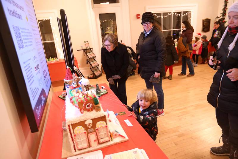 People look at the gingerbread house during the Old Courthouse Center Gingerbread House Walk before the Lighting of the Square on Friday, Nov. 28, 2025, in Woodstock.The annual holiday season event featured brass music, caroling, free doughnuts and cider, food trucks, festive selfie stations and shopping.