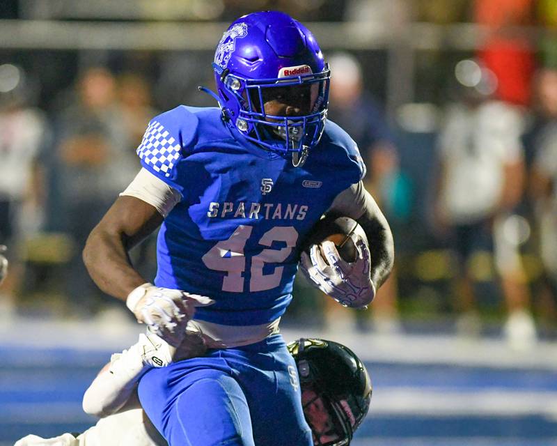 St. Francis's Tivias Caldwell jr. (42) runs in for a touchdown during the game on Friday Oct. 3, 2025, while being held back by an IC Catholic Prep player held at St. Francis High School.