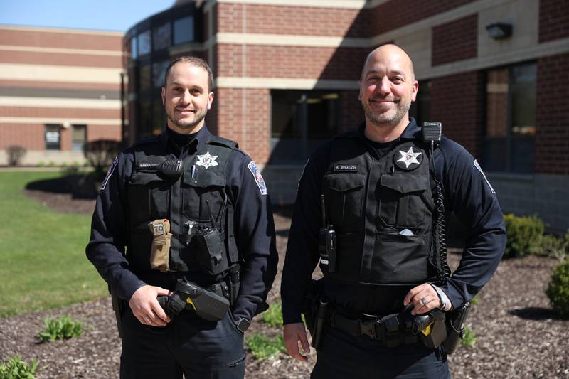 Lockport Police Officer and LTHS Resource Officers Cameron Kamarauskas, left, and Kevin Brauch pose for a photo outside Lockport high school’s main campus on Monday, April 8.