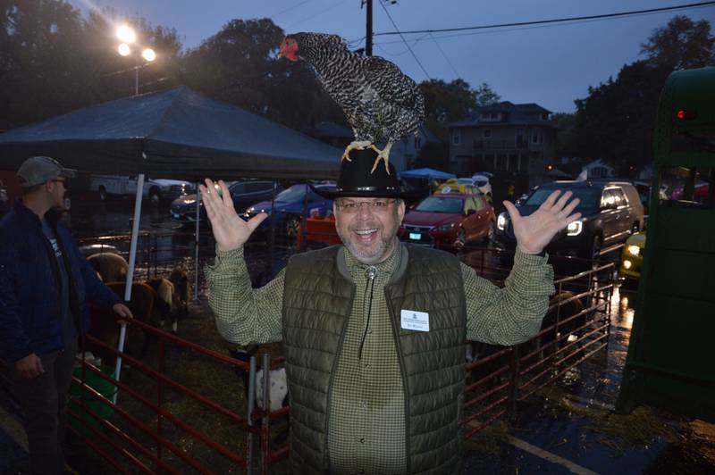Boy Mircea, associate pastor at First Presbyterian Church of Joliet and cowboy at the church's 2023 Trunk 'N Treat event, poses with a live chicken on his head. Approximately 800 people braved teeming rain for the Joliet church’s 15th Trunk ‘N Treat event on Oct. 28.