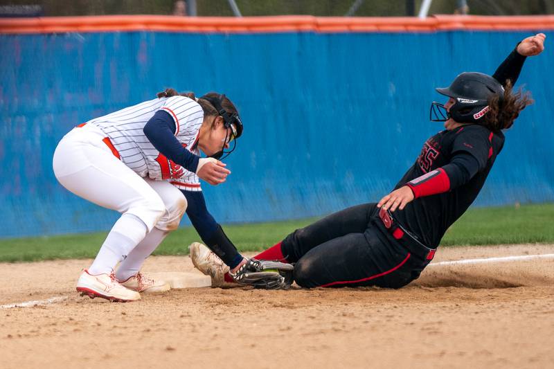 Oswego’s Kiyah Chavez (left) tags Yorkville's Kayla Kersting for an out during a softball game at Oswego High School on Tuesday, April 25, 2023.