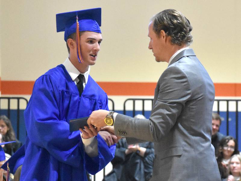 Connor Grimm shakes hands with Genoa-Kingston School Board President Matt Krueger as he receives his diploma during the graduation ceremony Saturday, May 20, 2023, at Genoa-Kingston High School.