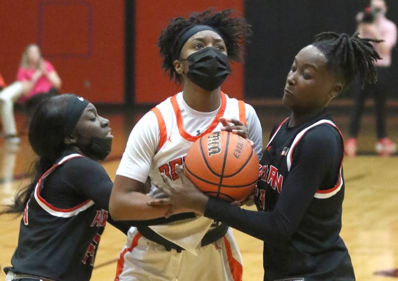 DeKalb's Amina Gray tries to split two Rockford Auburn defenders on her way to the basket Monday, Feb. 14, 2022, during their IHSA Class 4A regional game at Harlem High School in Machesney Park.