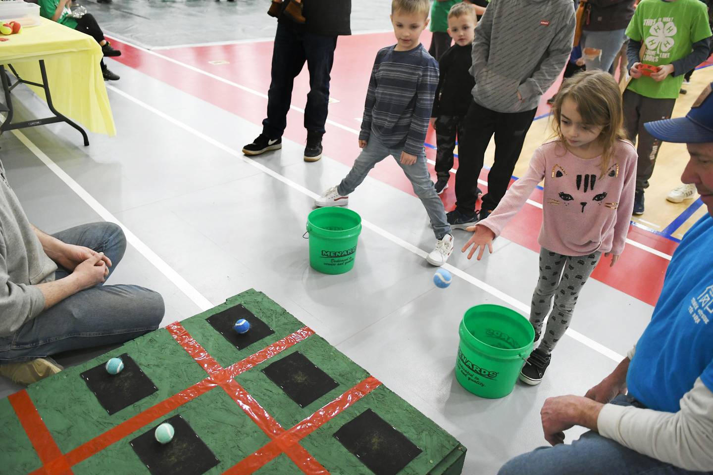 Gwenyth Stanfa, 6, of Rochelle, tosses a ball at a tic-tac-toe board as Cooper Ellison, 6, of Byron watches during the 4-H Penny Carnival on Saturday, March 18. The Pine Creek Valley 4-H Club offered this game for kids.