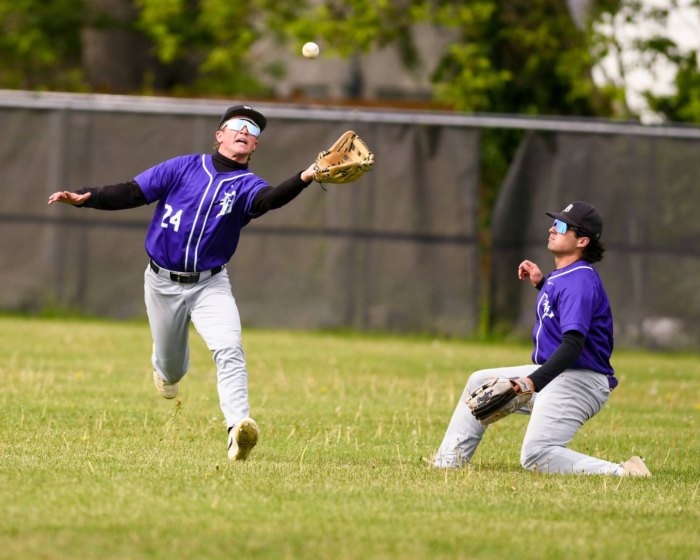 Downers Grove North's Russ Oros, left, makes a catch for an out during the game on Monday May 19, 2025, while taking on York High school in Elmhurst.