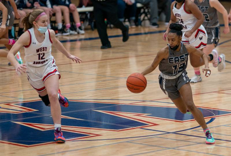 Oswego East's Cydnei Mitchell (13) brings the ball up the court against West Aurora during a basketball game at West Aurora High School on Wednesday, Jan 26, 2022.