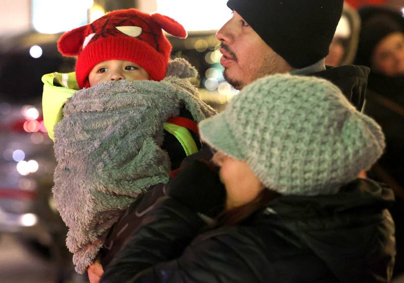 Visitors try to stay warm as they wait in line to see Santa Thursday, Dec. 5, 2024, during the DeKalb Chamber of Commerce’s Lights on Lincoln and Santa Comes to Town.
