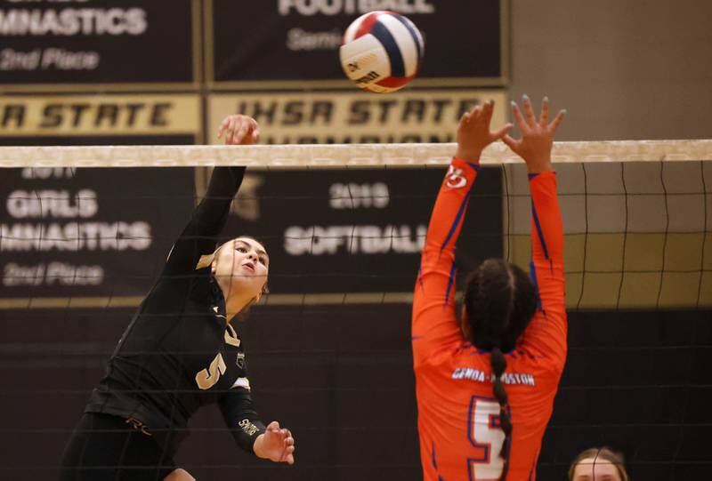 Sycamore's Kylie Walsh tries to spike the ball past Genoa-Kingston's Mia Wise during their match Monday, Aug. 28, 2023, at Sycamore High School.