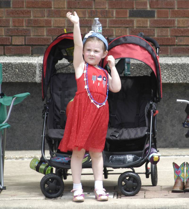 Dani Withers of Dixon waves to passing floats during the Petunia Festival parade on Sunday, July 6, 2025.