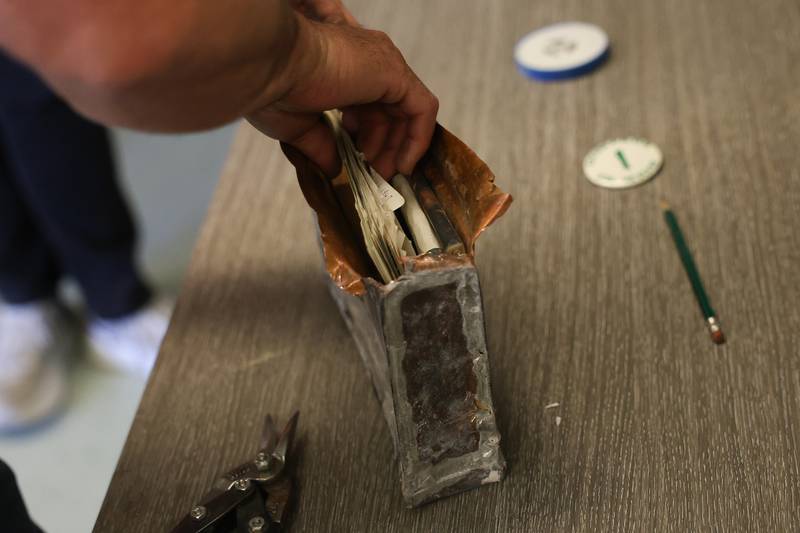 Randy Williams removes letters from a time capsule at Grompers Junior High School on Wednesday, May 1, 2026 in Joliet. In 1969 students placed items in a time capsule and sealed it inside a wall when an extension was built at Grompers Junior High School.