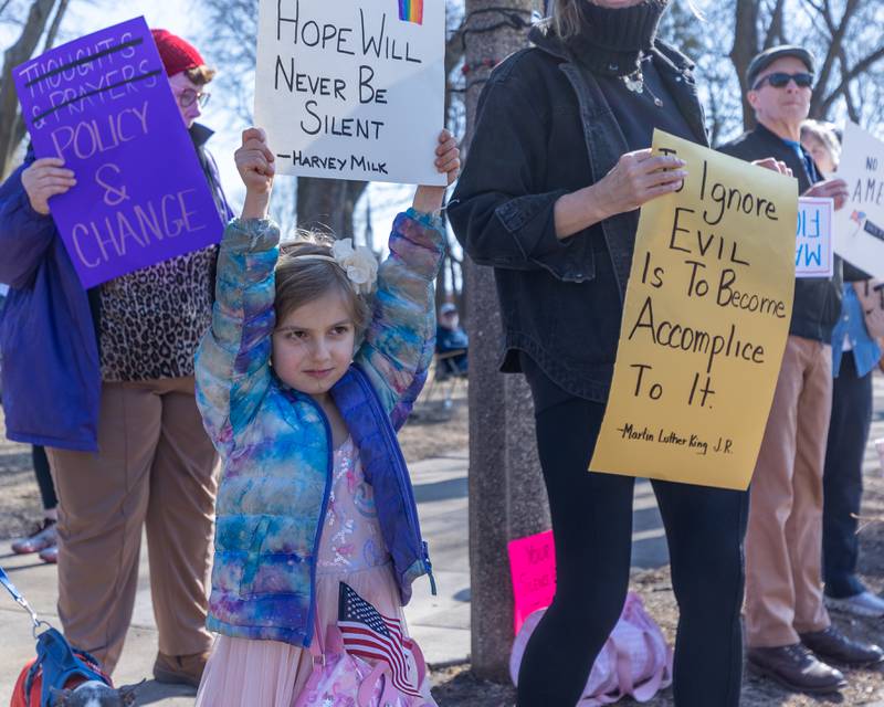 Child holds sign at the 'Pretti good time for a Protest' on Feb. 15, 2026 at Washington Square Park in Ottawa.