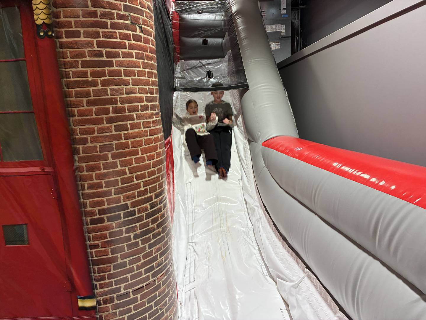 Gene and Pam Meliksetyan's children ride the slide at the fire station bouncy house at Kids Garage on Wednesday, Dec. 31, 2025. The couple opened the business at 2309 N. Ringwood Road Unit GH, McHenry, in October.