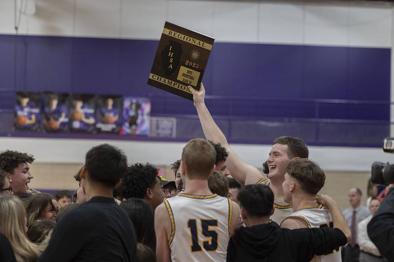 Sterling’s Lucas Austin raises the regional plaque after beating Ottawas 74-56 in the regional final Friday, Feb. 24, 2023.