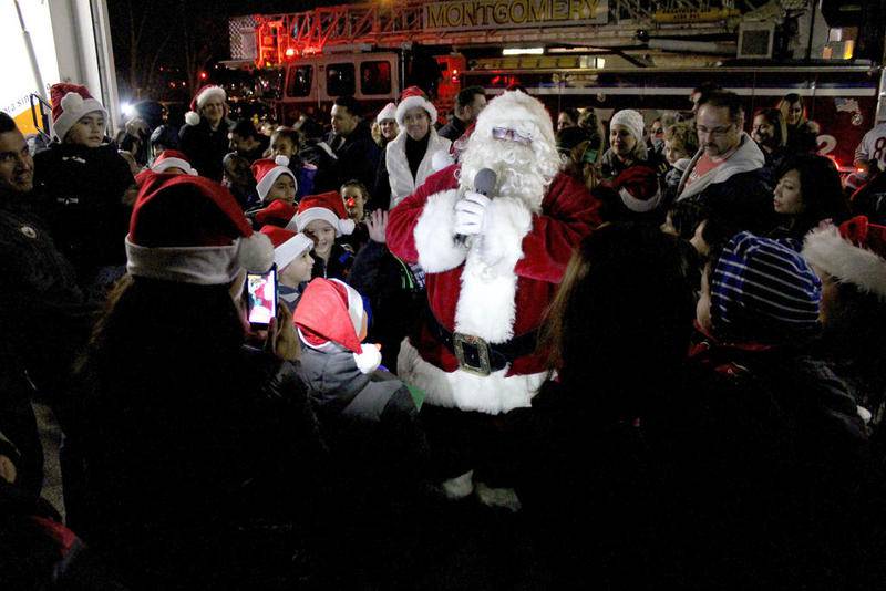 Santa Claus greets children while making his way to Montgomery's Christmas tree at the annual tree lighting ceremony at the Village Hall on Sunday. After lighting the tree, Santa and Mrs. Claus visited with local children inside of the hall.