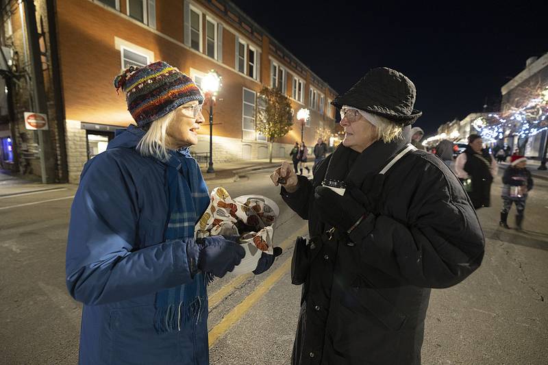 Cindy Thompson (right) plucks a fresh roasted chestnut from Sarah Bingamam Friday, Dec. 6, 2024, in Dixon.
