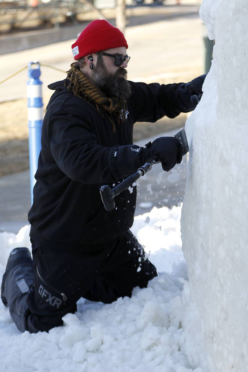 Dusty Thune, a snow carver from Minnesota, works on a sculpture named “Nature Prevails” on Thursday., Jan. 30, 2025, Snow carvers have started carving their 15 massive snow sculptures for America’s Snow Sculpting Invitational during Winterfest in Lake Geneva. Winterfest, runs through Feb, 2, 2025. The warm and rainy weather has slowed down the carving of the snow.