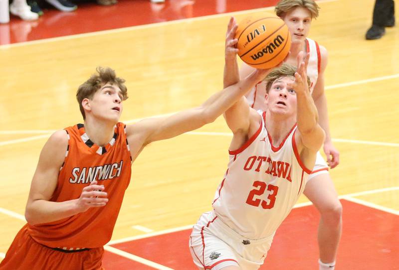 Ottawa's Owen Sanders grabs a rebound over Sandwich's EJ Treptow on Wednesday, Dec. 4, 2024 in Kingman Gym at Ottawa High School.