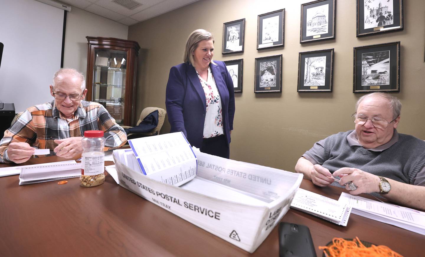 DeKalb County Clerk Tasha Sims visits with election judges Terry Heiland (left) and Steve Nemeth as they put vote-by-mail ballots in envelopes Wednesday, Feb. 22, 2023, in the DeKalb County Administration Building in Sycamore.