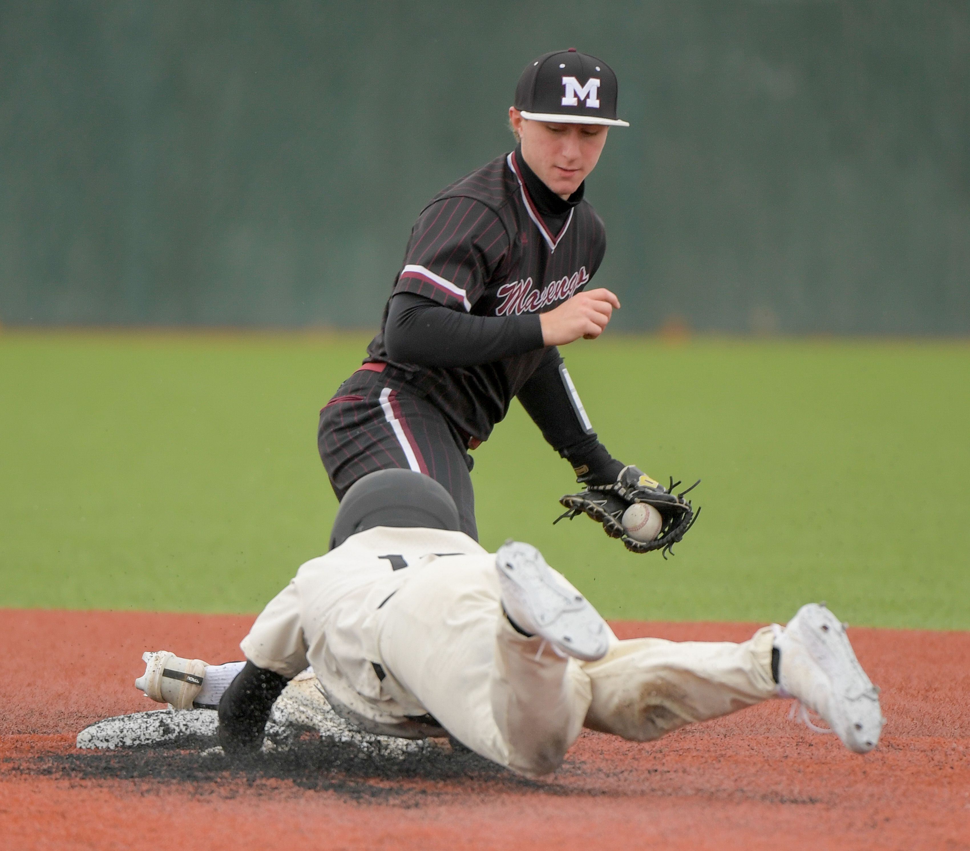 Marengo's Quinn Lechner (8) makes the tag on Streamwood's Miguel Rodriguez (10) during a game on Monday, March 25, 2024 in Carol Stream.