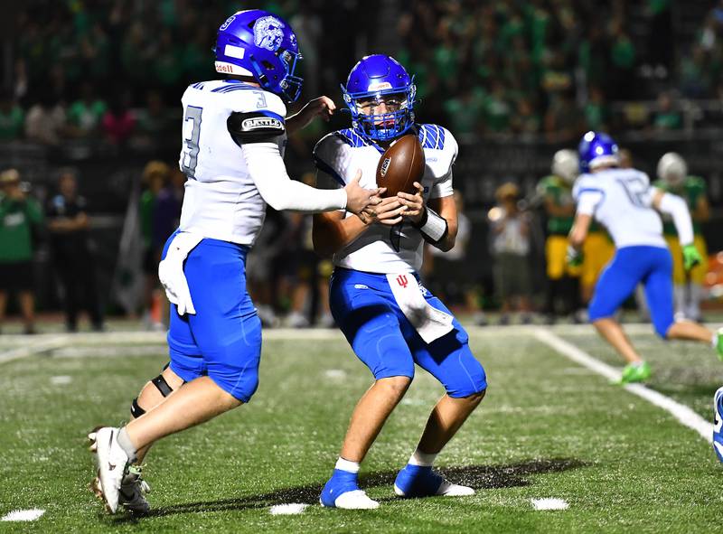 St. Francis Brock Phillip (1) hands the ball off to Drew Kegebein during the non-conference game against Providence Catholic on Friday, SEP. 26, 2025, at New Lenox.