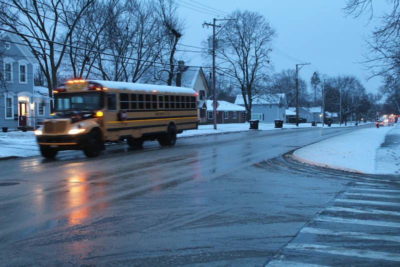 A school bus drives down McHenry Avenue in Crystal Lake Tuesday morning. Many schools have closed due to the snow storm.