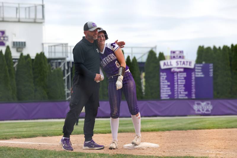 Manteno's Aubrie Goudreau gets a hug from head coach Josh Carlile as she reaches third base during Beecher's 14-6 victory over Manteno in the Class 2A Manteno Regional championship on Friday, May 22, 2026.