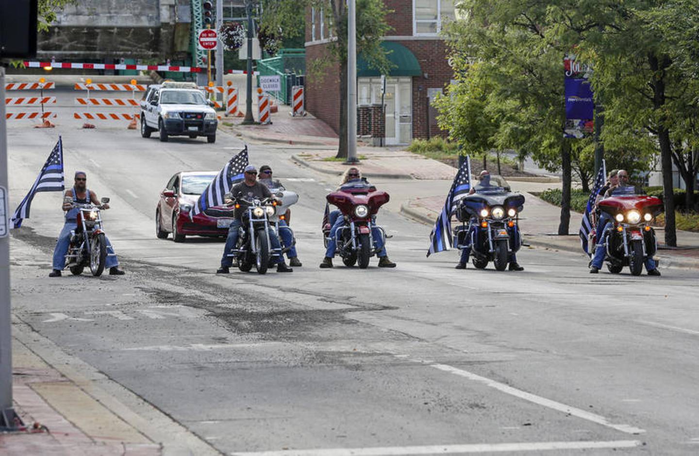 A small counter protest of Blue Lives Matter demonstrators can be seen following Black Lives Matter protestors on Saturday, Aug. 22, 2020, in Joliet, Ill.