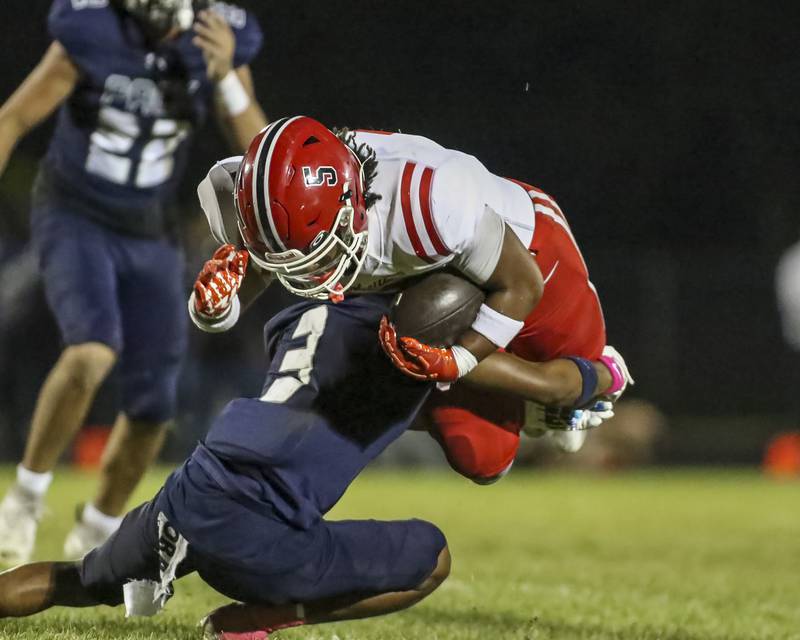 Oswego East's Zamarion Taylor (3) up ends Yorkville's T.J. Harland (5) during football game between Yorkville at Oswego East Friday, Oct 10, 2025 in Oswego.