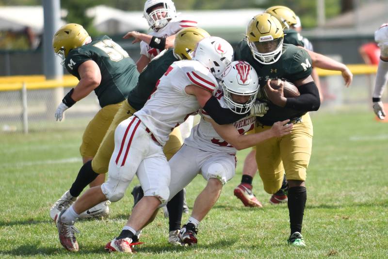 Bishop McNamara's Jordan Callaway, right, sheds a pair of Lawrenceville defenders during a game at Bishop McNamara Saturday, Aug. 30, 2025.