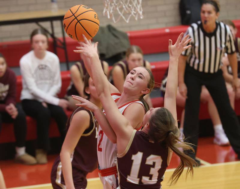 Ottawa's Ashlynn Ganiere gets inside to score on a layup over Morris's Tessa Shannon on Tuesday, Dec. 9, 2025 in Kingman Gymnasium at Ottawa High School.