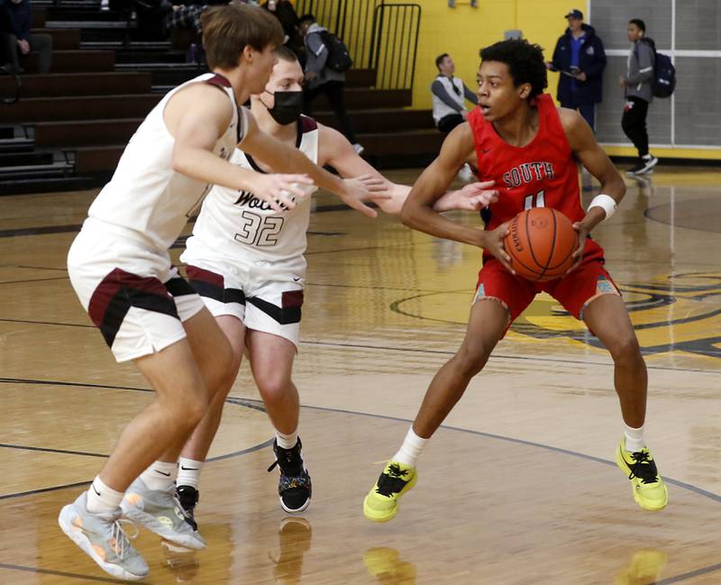 South Elgin’s Elias Williams (right) is defended by Prairie Ridge's Cade Collins (left)  and Prairie Ridge's Kevin Fist (center) during a Hinkle Holiday Classic basketball game Tuesday, Dec. 27, 2022, at Jacobs High School in Algonquin.