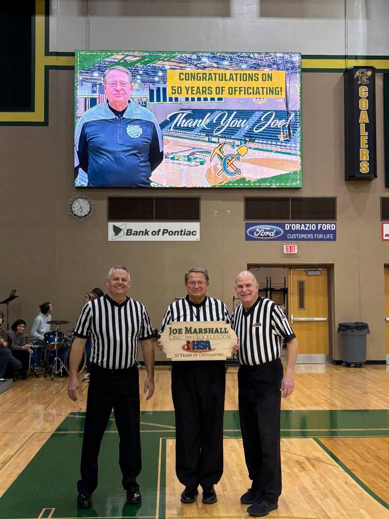 Joe Marshall (center) was honored during Coal City's regular season finale by having the officials locker room named after him.