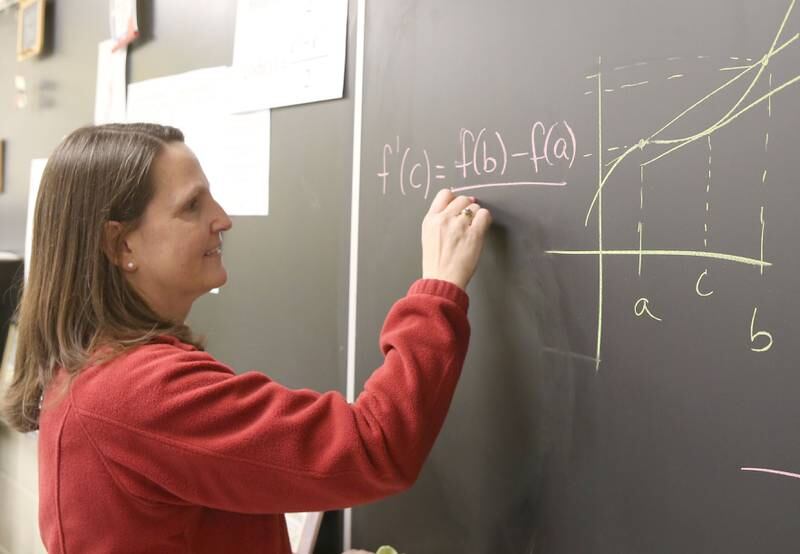 Mrs. Jenna Maierhofer writes a math problem on the chalkboard on Tuesday, March 18, 2025 at Seneca High School.