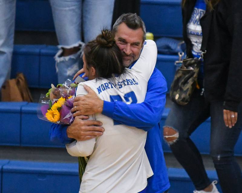 St. Charles North's Haley Burgdorf (23) receives a hug from her dad Ken Burgdorf after Haley made her 1,000 career kill during the game on Wednesday Oct. 2, 2024, while traveling to take on St. Francis High School in Wheaton.