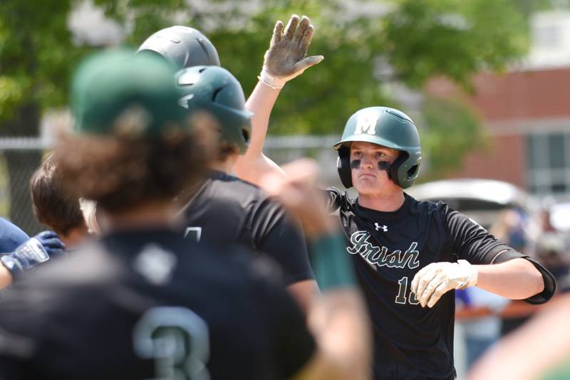 Bishop McNamara's Jacob Lotz, right, is greeted at home plate by his teammates after hitting a home run in the Class 2A Beecher Sectional championship game against Wilmington Saturday, May 31, 2025.