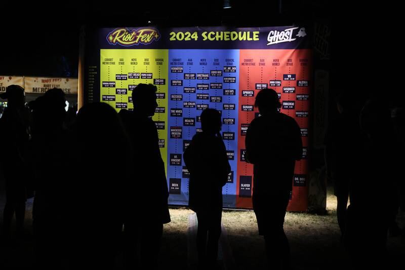 Festival goers check out the band list at Riot Fest on Saturday, Sept. 21, 2024 in Chicago.