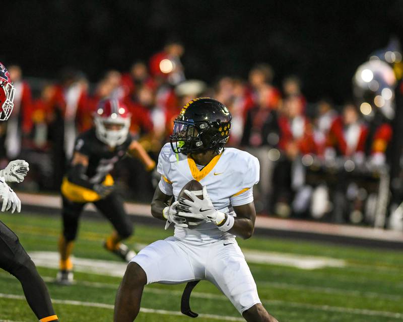 Joliet West's Jordan Bennett (1) catches the ball and gains some yards before being tackled by Yorkville players during the game on Friday Sept. 5, 2025, while traveling to Yorkville High School.