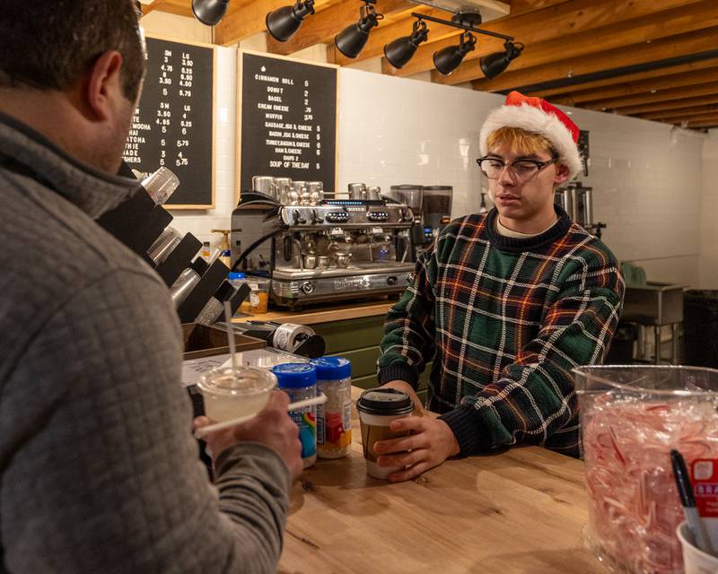 Mateo Goy hands customer drink on Sunday, December 14, 2025 at The Coffee Barn in Mendota.