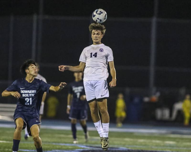 Downers Grove North's Grigore Onica (14) heads the ball during soccer match between Downers Grove North at Downers Grove South. Oct 2, 2025.