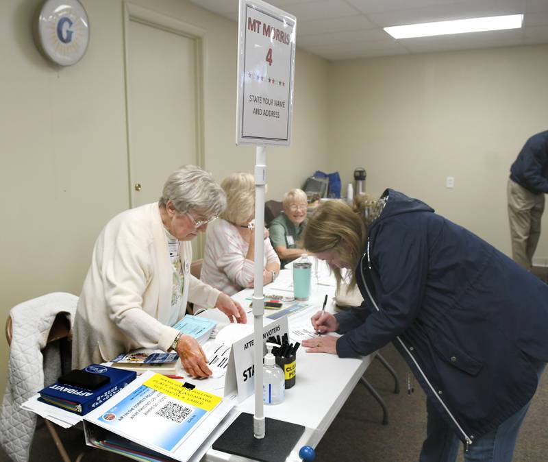 Sue Wright signs in to vote at the Mt. Morris Village Hall on Tuesday, April 4, 2023, with the assistance of election judges Marilyn Schwartz, Sharon Osborne and Joyce Duncan.