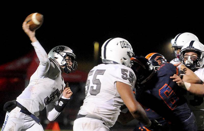 Oswego East quarterback Michael Ford (5) fires a pass over the Oswego defensive line during the varsity crosstown football game at Oswego High School on Oct. 28.