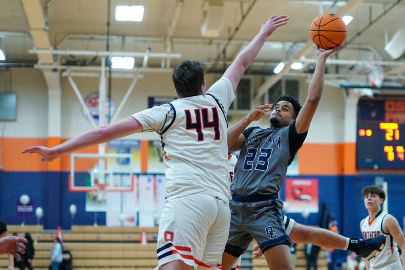 Oswego East's Torrin Ross (23) shoots the ball in the post against Oswego’s Hunter O’Neill (44) during a basketball game at Oswego High School on Tuesday, February 18, 2025.