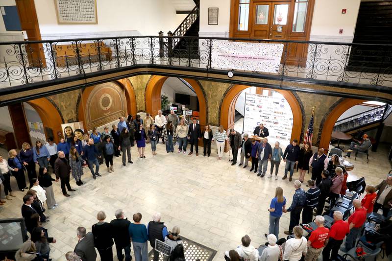 Participants join hands during the annual Hands Around the Courthouse in honor of National Child Abuse Prevention Month on Thursday, April 10, 2025 at the Kane County Courthouse in Geneva.
